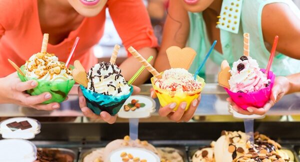 Heladerías - Personas sosteniendo copas de helado de diferentes sabores en una de las mejores heladerías en Madrid