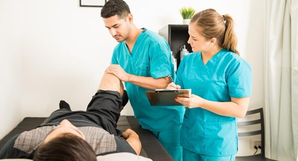 Mejores ortopedistas de rodilla - Traumatólogo revisando la rodilla de uno hombre en consulta con los mejores ortopedistas de rodilla en Madrid
