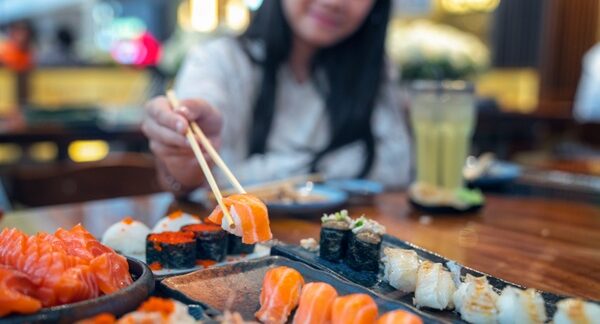 Mejores restaurantes japoneses - Mujer en un restaurante de comida japonesa probando diferentes platos de los mejores restaurantes japoneses en Madrid