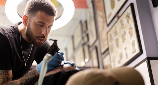 Mejores tatuadores - Tatuador realizando un tatuaje a un cliente reconocido como los mejores tatuadores en Madrid