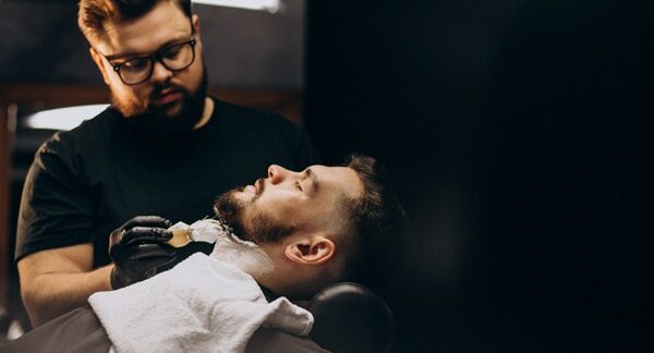 Barberías - Barbero de peluquería barbería hombre cortando la barba de un cliente en una de las mejores barberías en Madrid