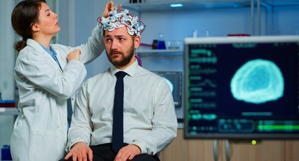 Centros para el dolor de cabeza - Neurólogo evaluando a un hombre con dolor de cabeza debido a migraña y cefalea en uno de los mejores centros para el dolor de cabeza en Madrid