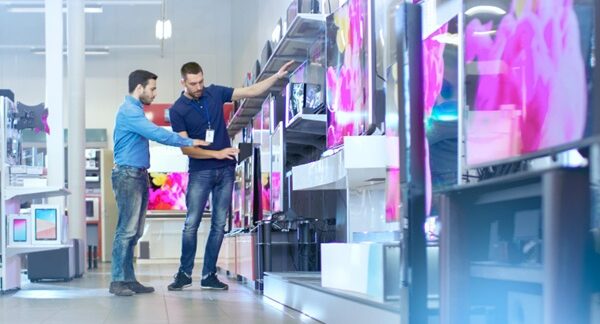 Tiendas de electrodomésticos - Vendedor de una de las mejores tiendas de electrodomésticos en Madrid atiendo a un hombre que busca aparatos eléctricos y utensilios del hogar