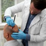 Tricólogos - Cirujano capilar reconocido como uno de los mejores doctores injerto capilar España realizando el boceto del injerto capilar a un hombre con alopecia avanzada