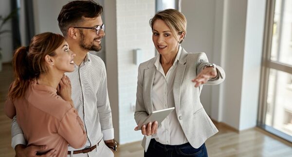 Agencias inmobiliarias - Asesora de inmobiliaria mostrando casas en venta a personas que buscan la compra o el alquiler de propiedades en Madrid