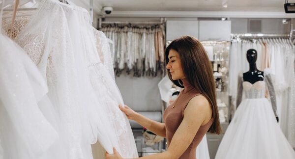 Vestidos de novia - Mujer observando varios modelos de trajes de novia para la boda en una de las mejores tiendas de vestidos de novia en Madrid