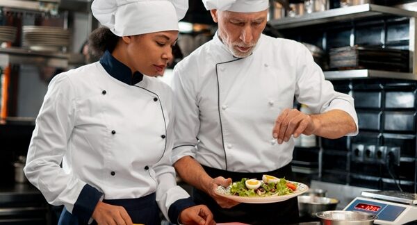 Escuelas de gastronomía - Cheff de academia de gastronomía enseñando a un cocinero en una de las mejores escuelas de gastronomía de Madrid