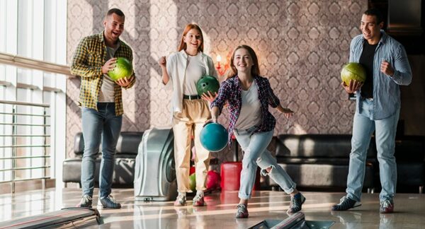 Clubes de bolos - Personas en una pista de boliche jugando bowling en uno de los mejores clubes de bolos de Madrid