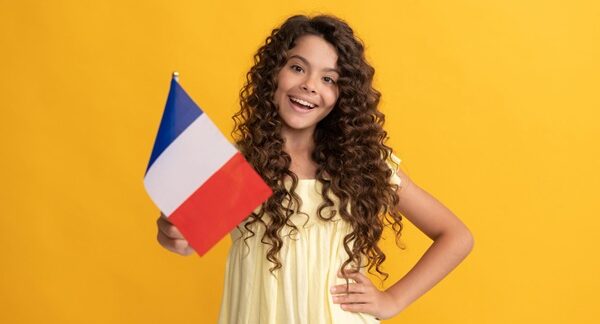 Escuelas de francés - Estudiante de un curso de francés sosteniendo una bandera de Francia en las clases de francés de las mejores academias de francés en Madrid