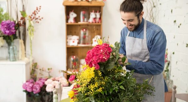 Floristerías - Hombre experto en arreglos florales armando un ramo de flores en una de las mejores floristerías de Madrid