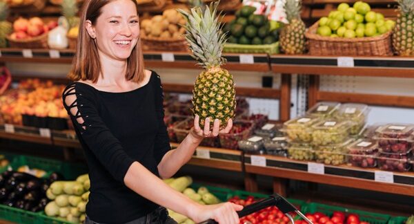 Tiendas de alimentos saludables - Mujer sonriente comprando alimentos saludables para una buena alimentación en una de las mejores tiendas de alimentos saludables en Madrid