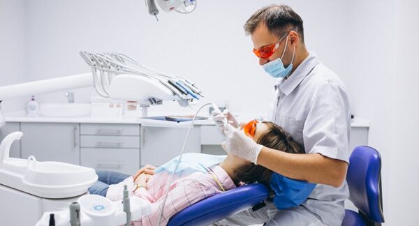 Hospitales de odontología - Dentista realizando un tratamiento dental a una mujer en la mejor clínica odontológica en Madrid