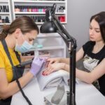 Salones de uñas - Especialista en estética de uñas realizando manicura a una mujer en uno de los mejores salones de uñas de Madrid