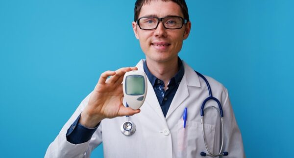 Centros de diabetes - Doctor especialista en diabetes sosteniendo un dispositivo de medición de niveles de azúcar en sangre en el mejor centro de diabéticos de Madrid