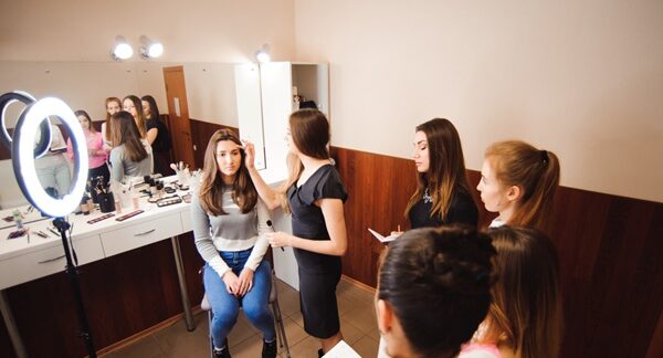 Academias de maquillaje - Estilista de una academia de maquillaje profesional en Madrid dando clases a varias chicas para aprender a maquillarse