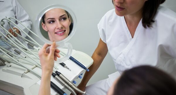 Dentistas estéticos - Dentista estético de Madrid mostrando los resultados de la intervención estética dental a una paciente femenina