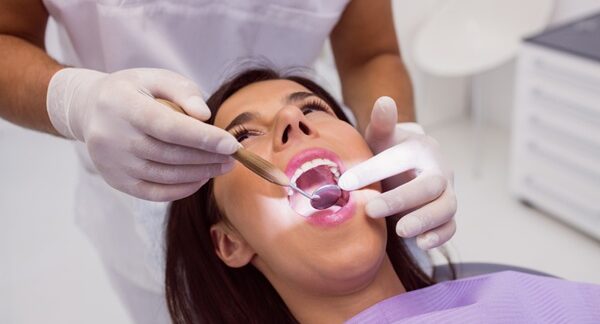 Periodoncistas - Dentista especialista en encías realizando un tratamiento periodontal a una mujer en la mejor clínica dental de Madrid