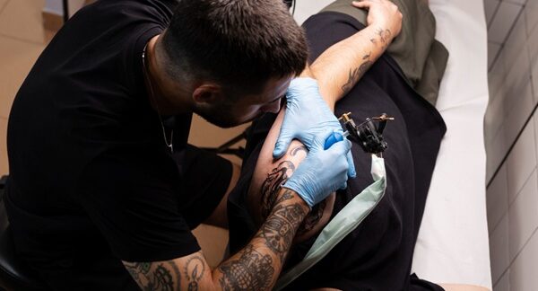Tatuajes realistas - Tatuador profesional realizando un diseño de tatuajes en realismo a un hombre en Madrid